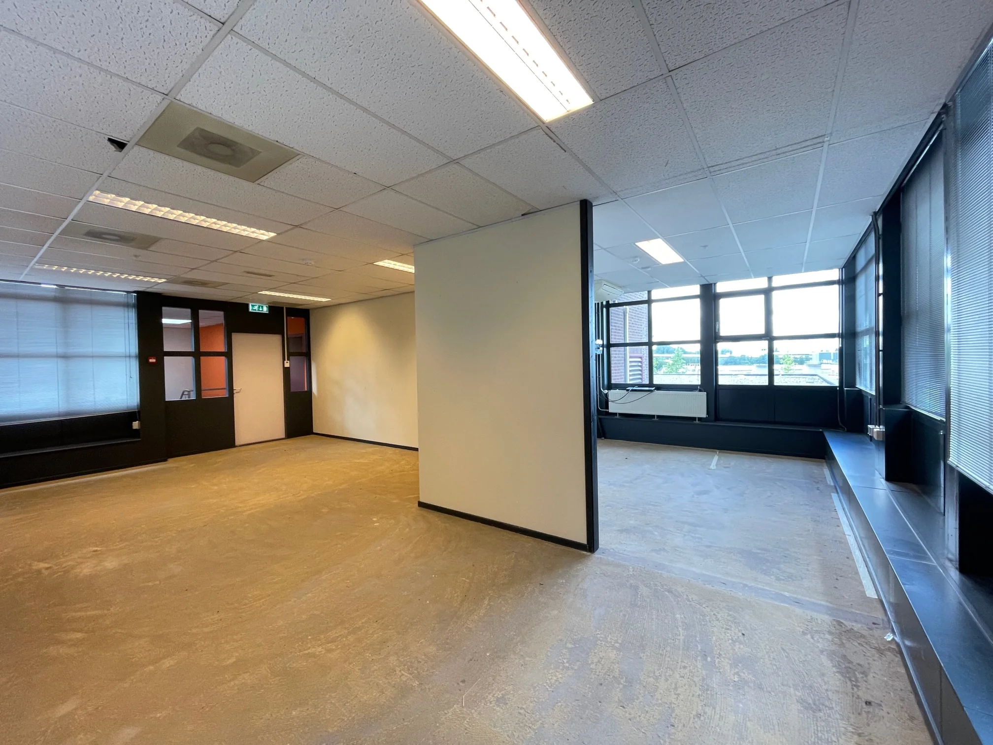 Leegstaand kantoorpand aan de Rivium 4e Straat met grote ramen en systeemplafond.